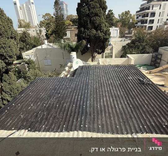 עבודת גג עם אדם על רקע עצים ובניינים